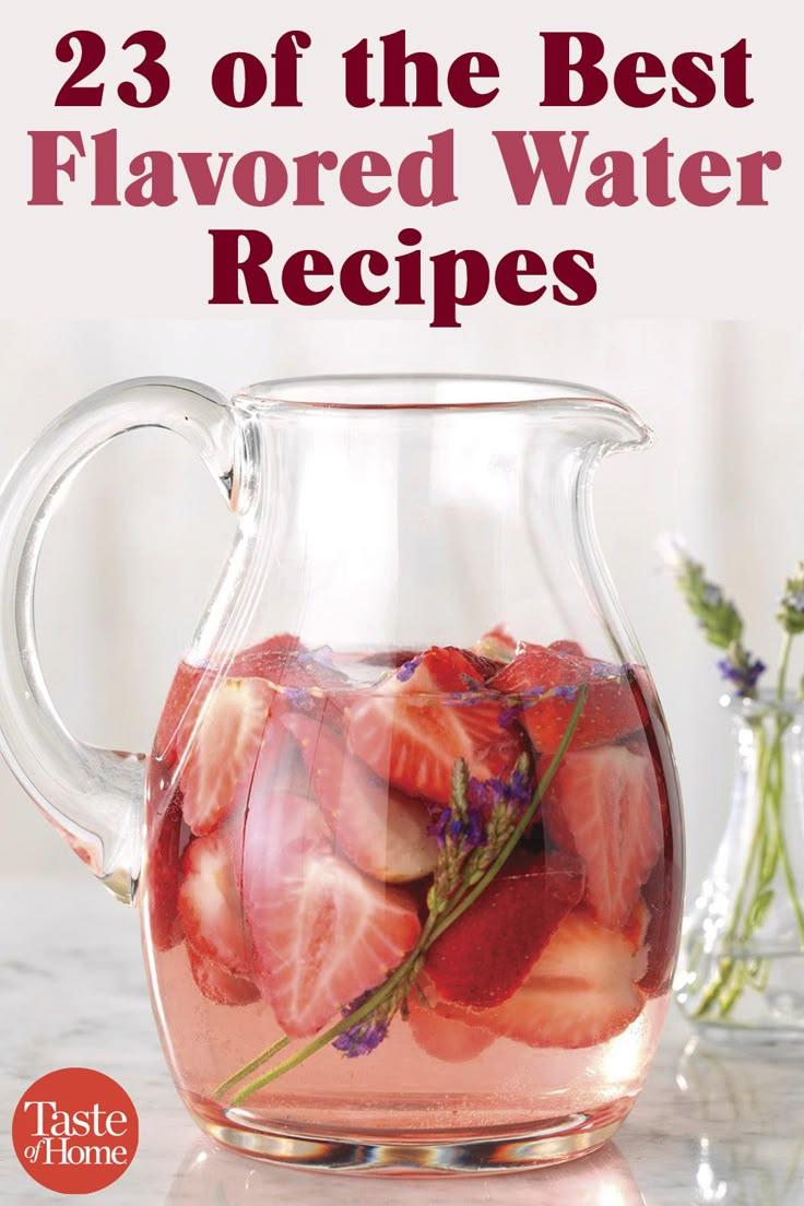 a pitcher filled with water and strawberries on top of a table