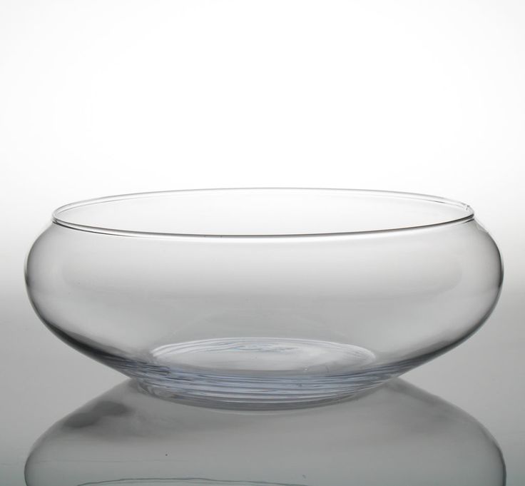 an empty glass bowl sitting on top of a reflective surface with water in the middle