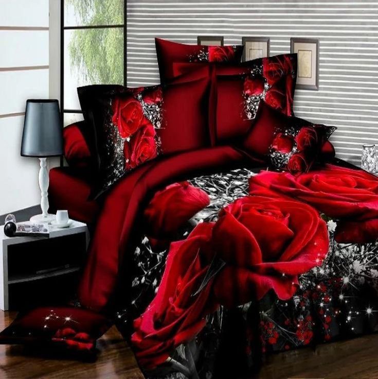 red roses on black and white bedding in a room with a lamp, table and chair