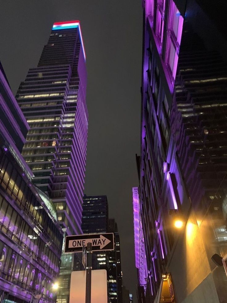 some very tall buildings in the city at night