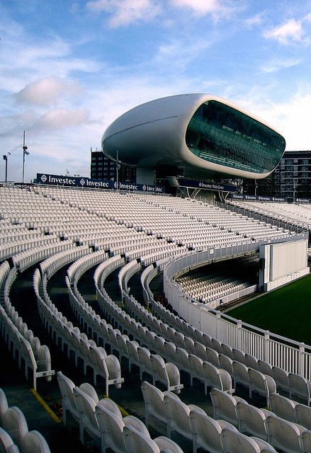 an empty stadium filled with white chairs under a blue sky