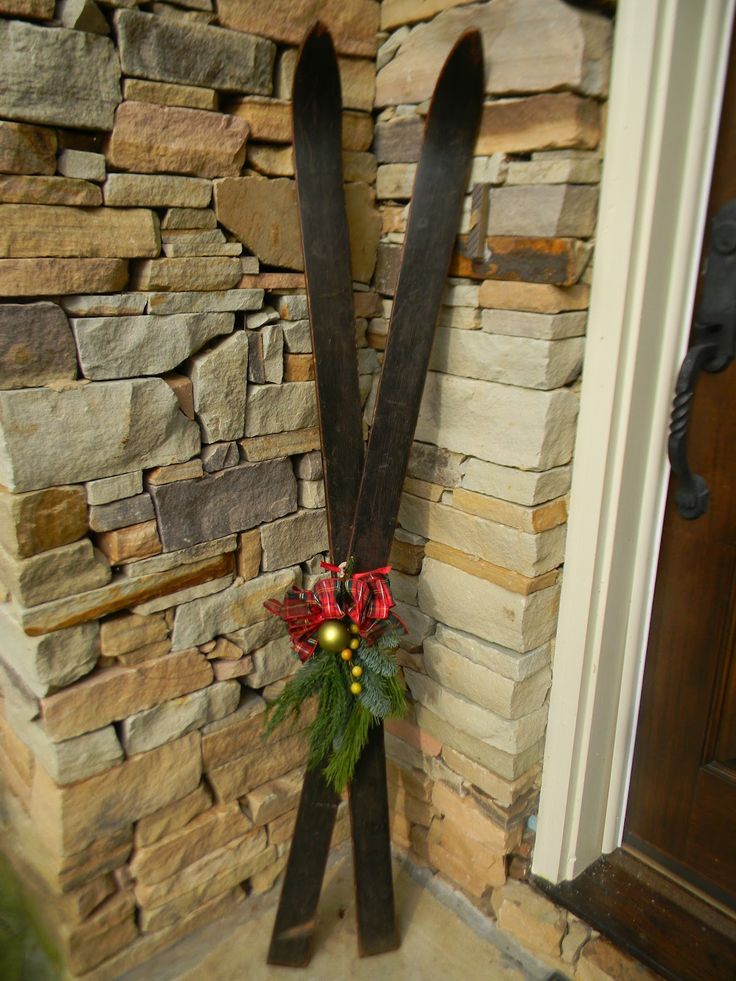 a pair of skis hanging from the side of a stone wall next to a door