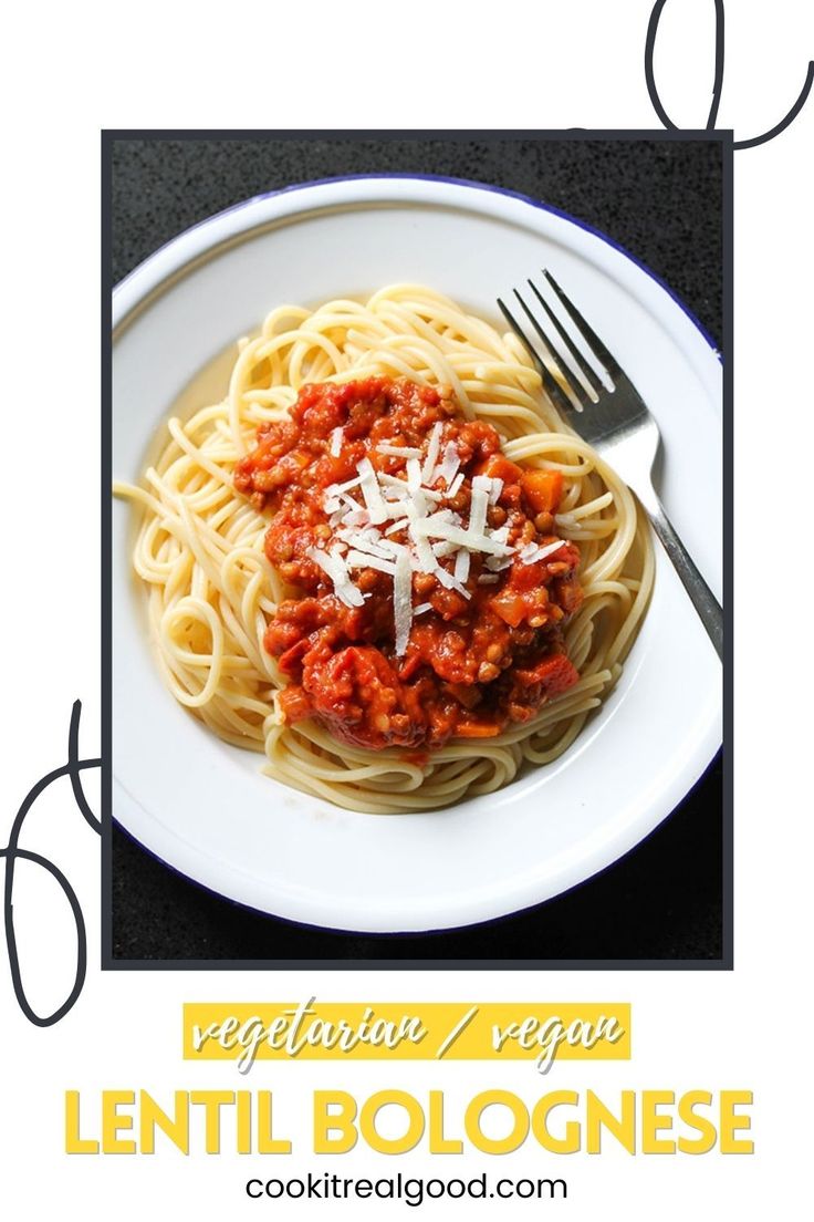 a white plate topped with spaghetti and sauce next to a fork on top of a table