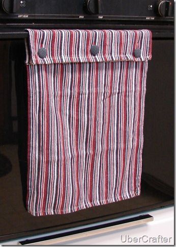 a red, white and blue striped towel hanging from a hook on a kitchen stove