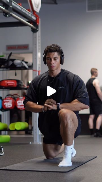 a man sitting on top of a mat wearing headphones