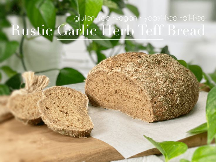 a loaf of bread sitting on top of a cutting board next to some green leaves