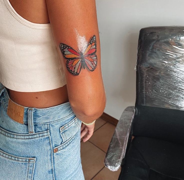 a woman with a butterfly tattoo on her arm