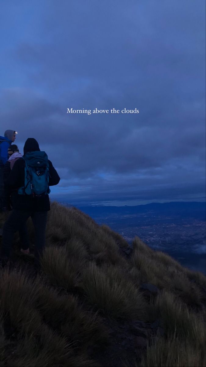 two people standing on top of a hill at night with the words morning above the clouds