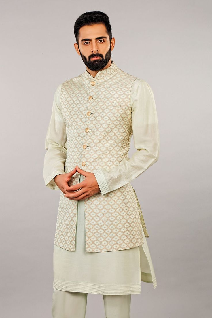 Mint kurta with band collar and full sleeves. Paired with self embroidered jaal bundi and straight pant. 
Component: 3
Embroidered
Neckline: Band Collar
Sleeve Length: Kurta: Full; Bundi; Sleeveless
Fabric: Silk
Color: White
Embroidered bundi
Front button placket
Straight fit pant - Aza Fashions Festive Chanderi Kurta With Naqshi Detail, Semi-stitched Pista Green Kurta With Naqshi, Festive Naqshi Chanderi Kurta, Elegant Chanderi Bandhgala For Festive Occasions, Elegant Festive Chanderi Bandhgala, Festive Naqshi Raw Silk Sets, Elegant Cotton Silk Nehru Jacket For Festive Occasions, Festive Cotton Silk Bandhgala For Formal Occasions, Elegant Fitted Bandhgala In Cotton Silk