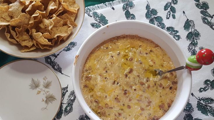 two bowls filled with dip and chips on top of a table