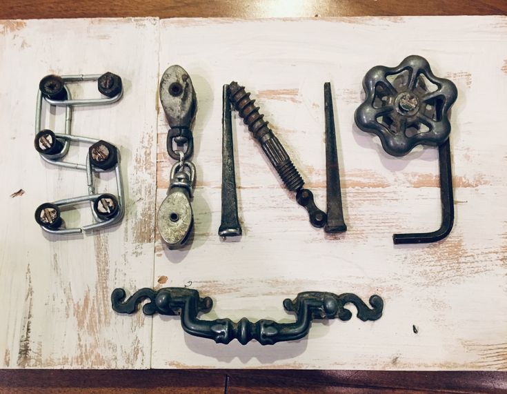 several different types of metal objects are arranged on a white board with the word love spelled out