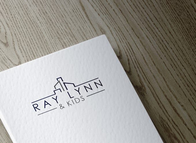 the logo for ray lynn and kids is displayed on a piece of paper that sits on a wooden surface