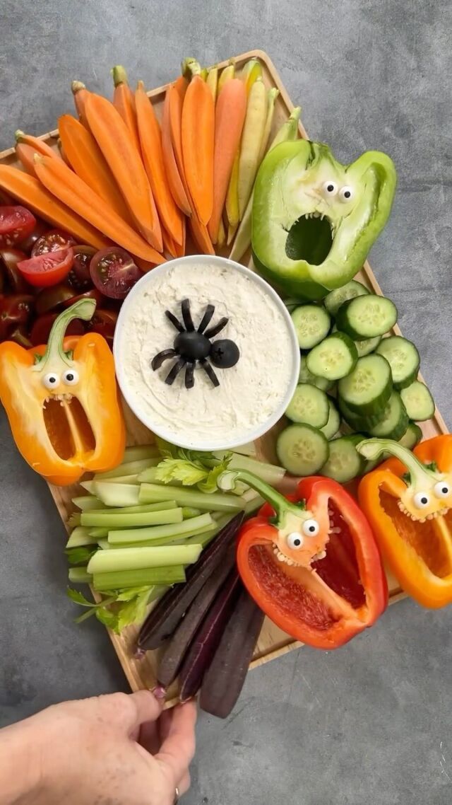 a tray with vegetables and faces on it