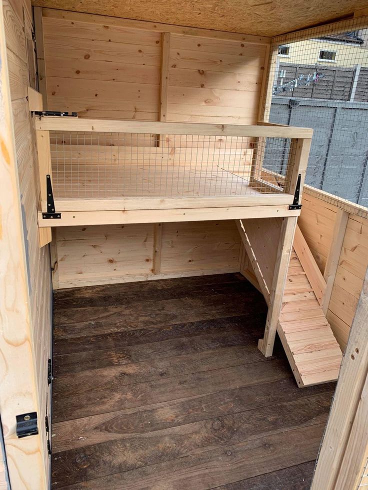 the inside of a chicken coop with wooden flooring and shelving units on each side