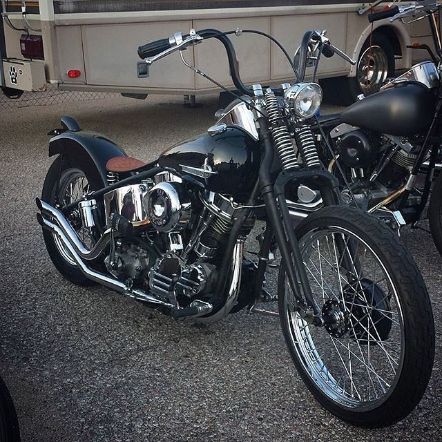 two motorcycles parked next to each other in front of a truck and another vehicle behind them