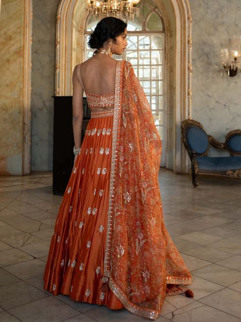 Editor's Note Introducing an exquisite rust heavily hand-embroidered lehenga set, paired with our signature printed organza-based dupatta. The intricate hand embroidery, featuring jaal, motifs,... Orange Georgette Sets For Festivals, Orange Georgette Sets For Reception, Designer Orange Choli With Intricate Embroidery, Designer Wear Orange Choli With Intricate Embroidery, Festive Orange Set With Sheer Dupatta, Orange Anarkali Set With Sheer Dupatta, Orange Sharara With Sheer Dupatta For Navratri, Orange Dress With Intricate Embroidery, Designer Orange Lehenga With Intricate Embroidery