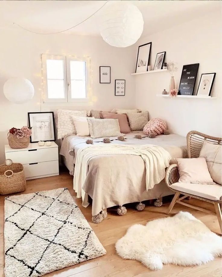 a bedroom with white walls and flooring, rugs and pictures on the wall