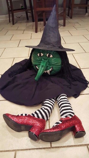 there is a green witch sitting on the floor