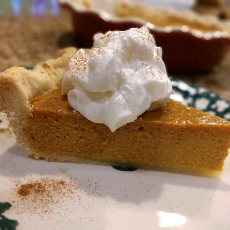 a slice of pumpkin pie with whipped cream on top