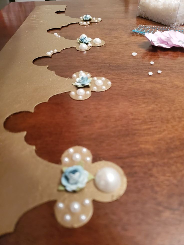 a wooden table topped with flowers and pearls