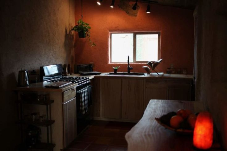 a kitchen with an oven, dishwasher, sink and table in the middle