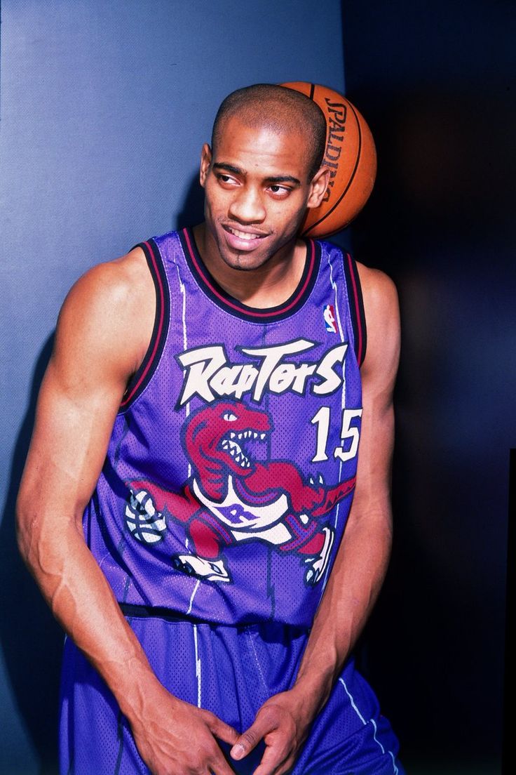 a man in a purple jersey holding a basketball