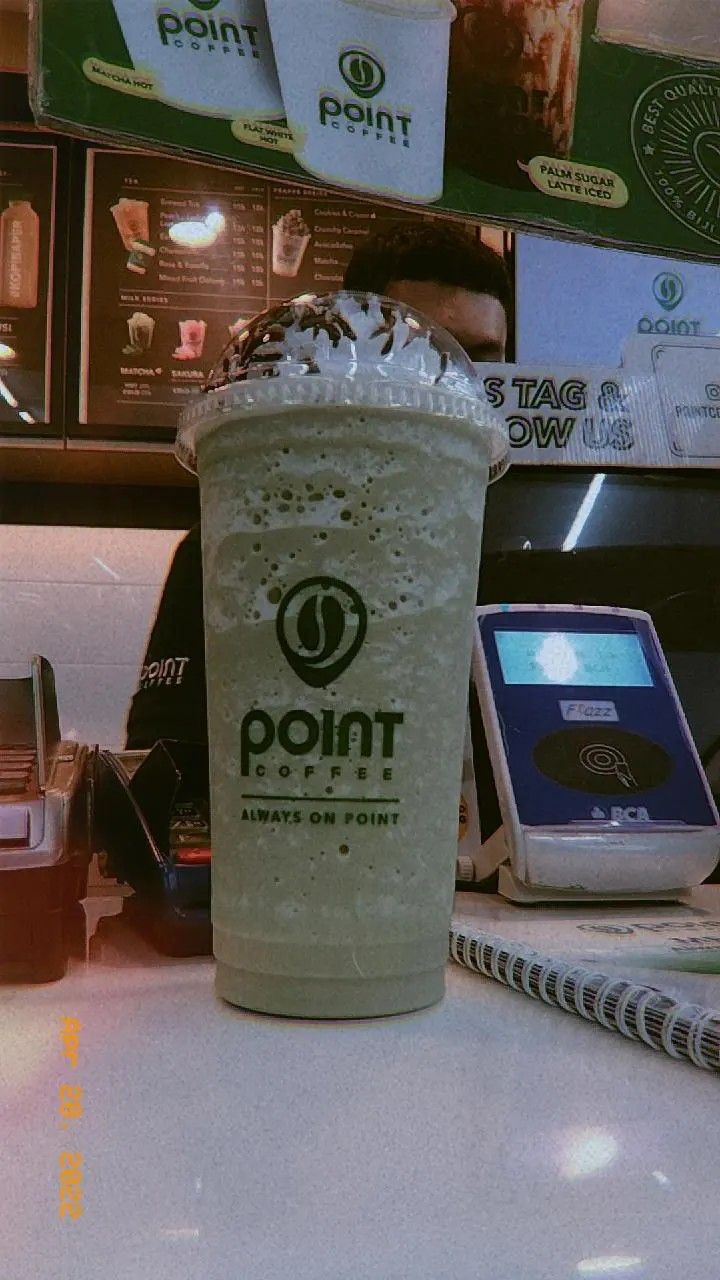 a drink sitting on top of a counter next to a cell phone