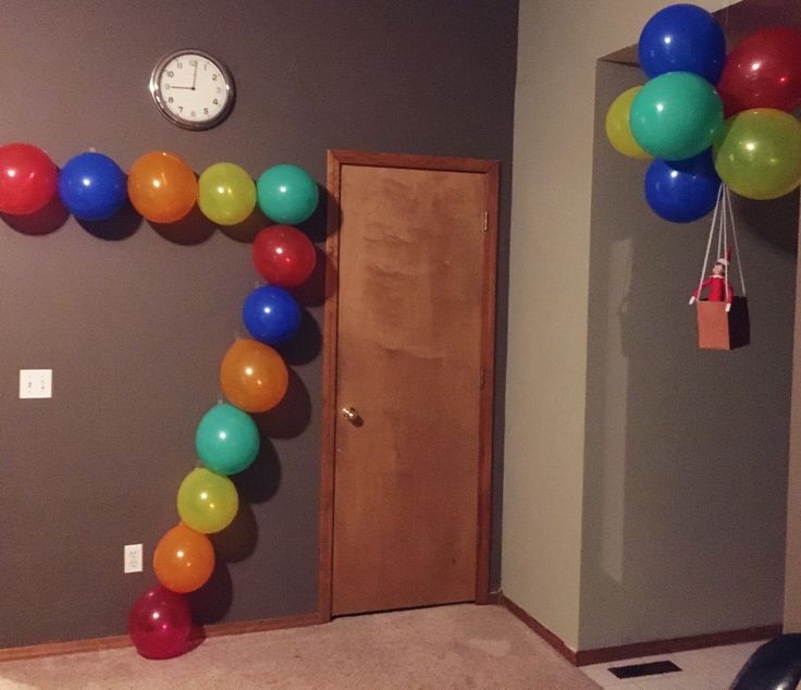 a room with balloons and a clock hanging on the wall next to it's door