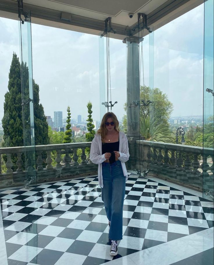 a woman standing in front of some glass windows