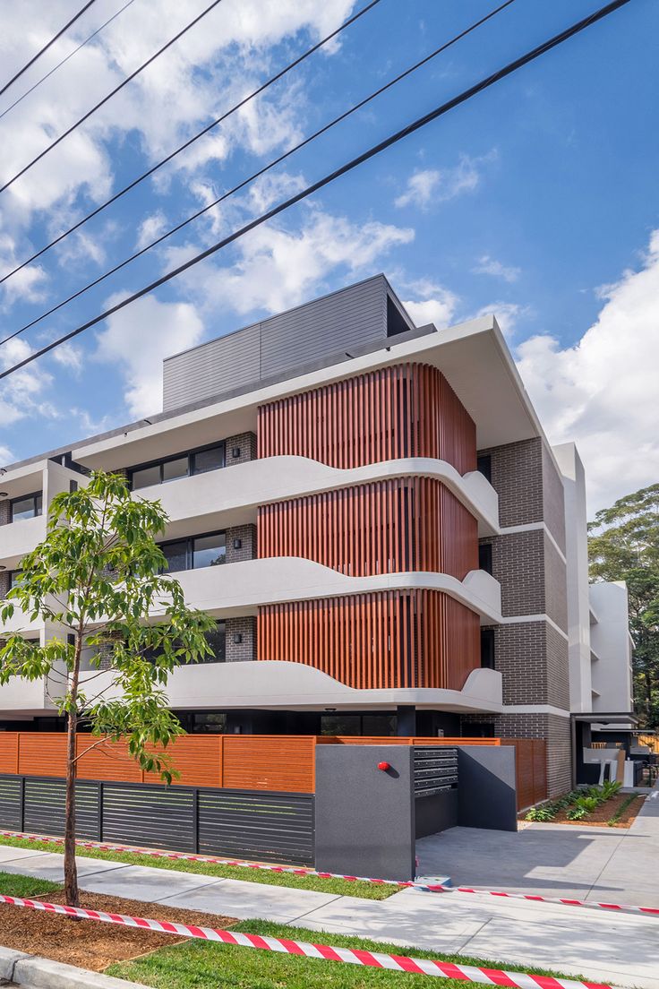 an apartment building with wooden slats on the front and sides, surrounded by trees