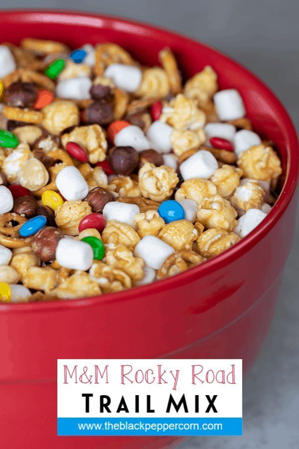 a red bowl filled with m & m rocky road trail mix and marshmallows