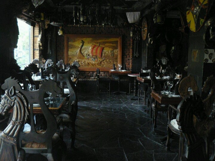 the dining room is set up for an event with large paintings on the walls and tables