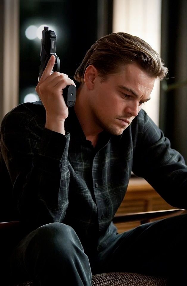 a man sitting down holding a cell phone to his ear