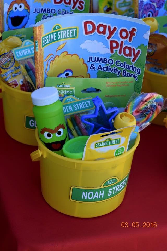 two buckets filled with toys on top of a red cloth covered table next to each other