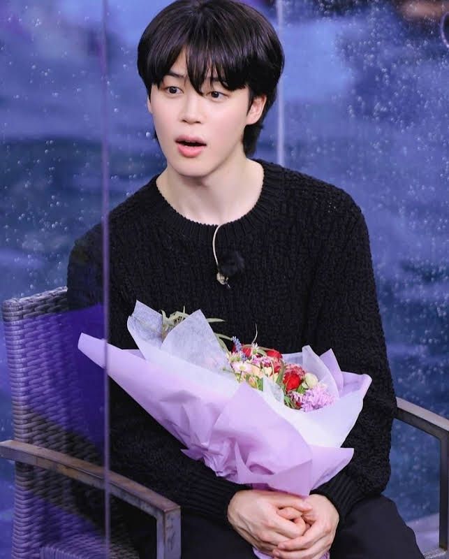 a person sitting down holding a bunch of flowers