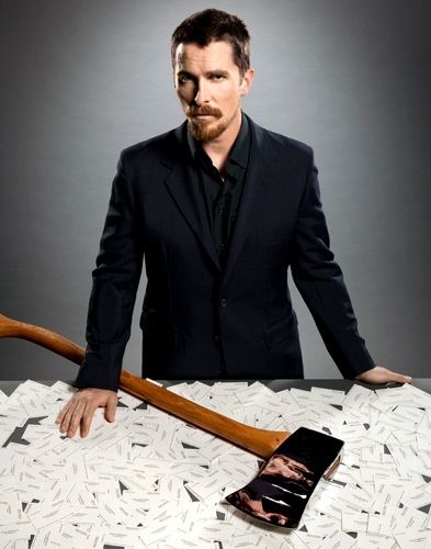 a man in a suit and tie holding a baseball bat on top of a table