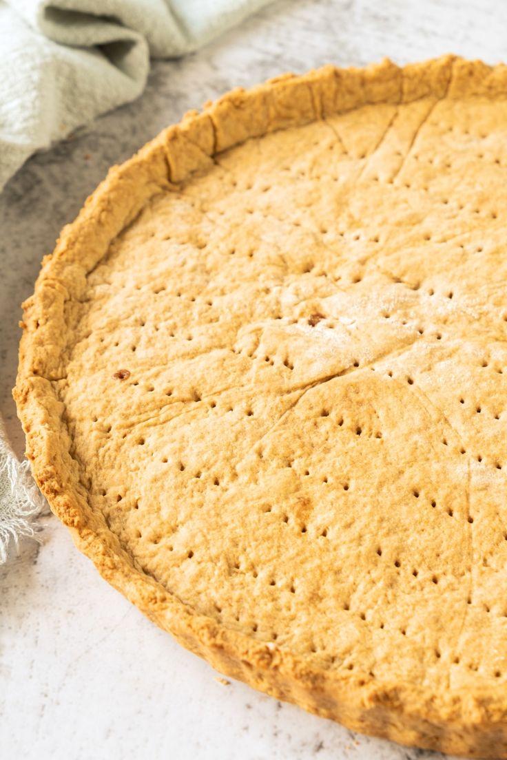 an uncooked pie sitting on top of a table next to a white towel