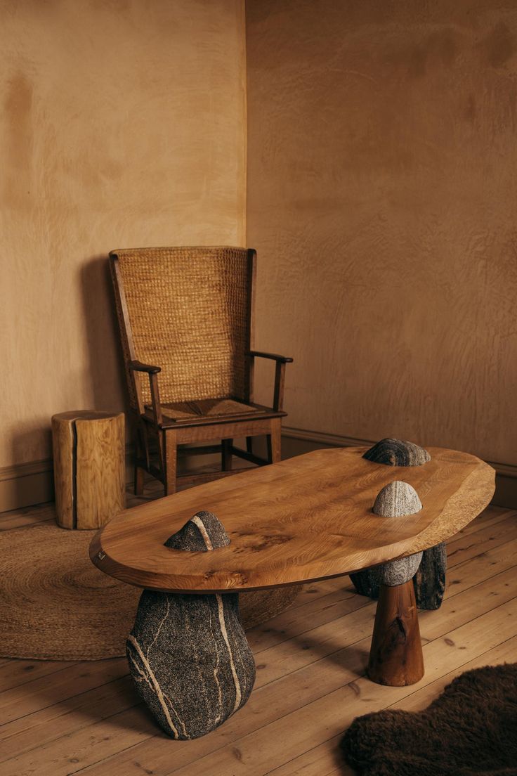 a wooden table sitting on top of a hard wood floor next to a rocking chair