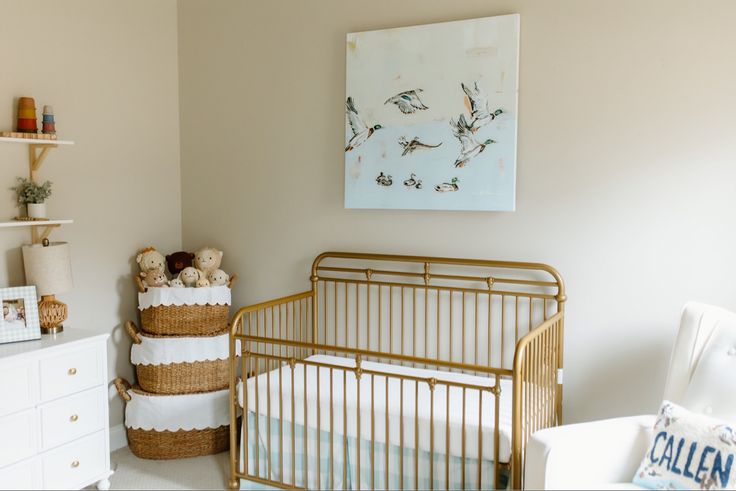 a baby's room with a gold crib and white dresser