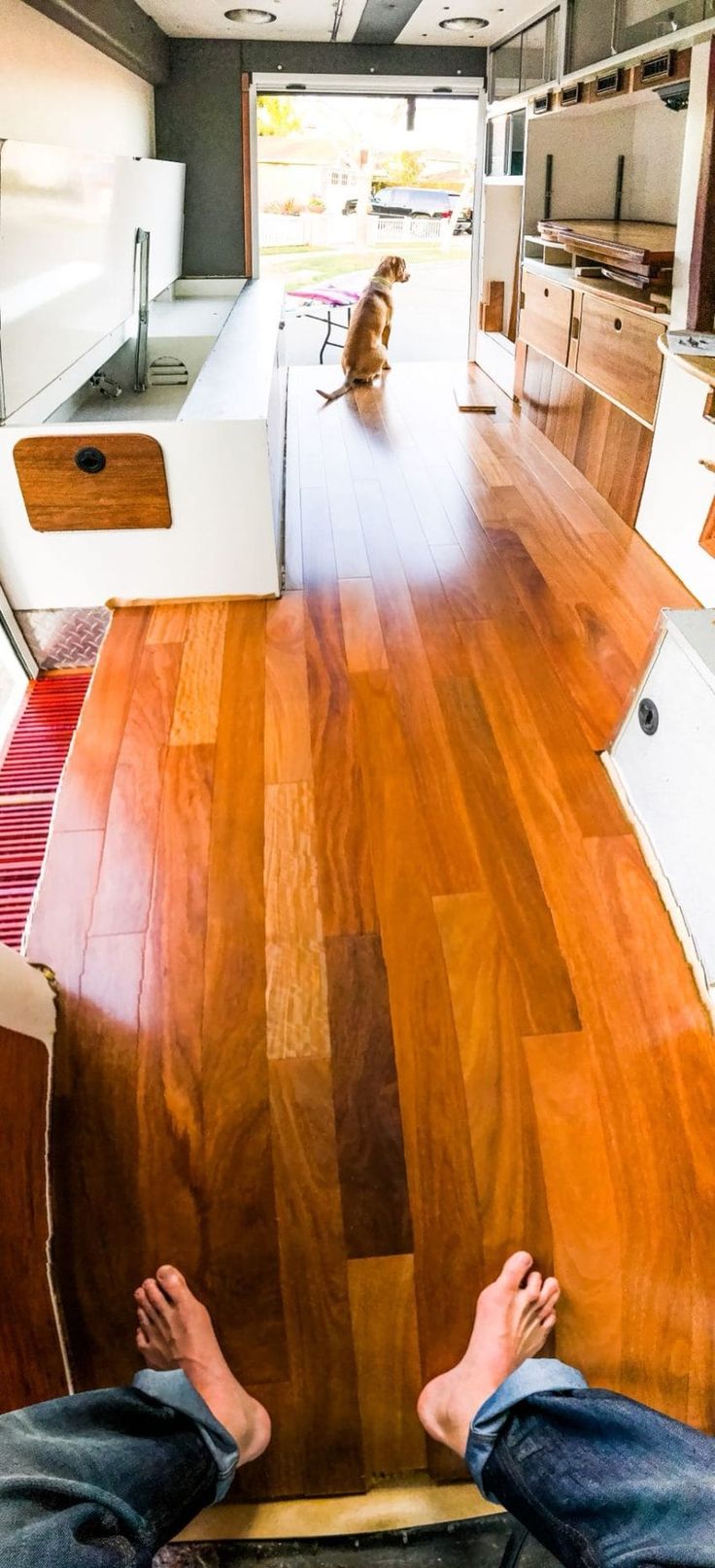 a person sitting on the floor with their feet up in front of an open kitchen