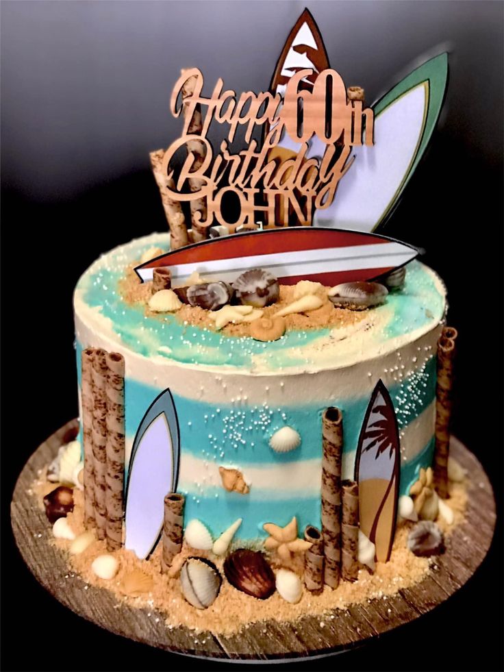 a birthday cake decorated with surfboards and sand