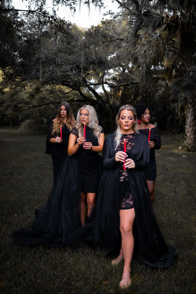 four women dressed in black posing for the camera