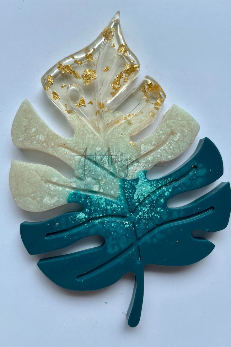 three pieces of blue and white brooch with gold leaf shapes on it's sides