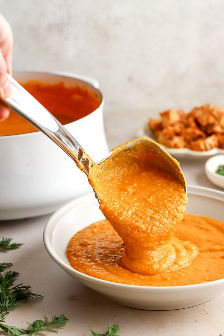 a spoon full of soup being lifted from a bowl