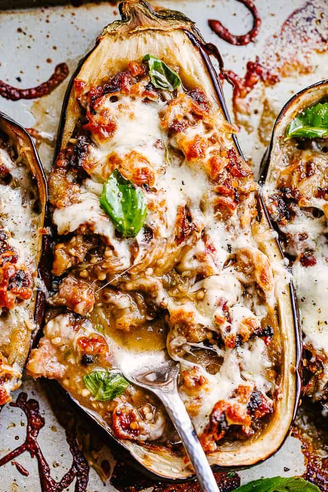 stuffed eggplant with cheese and herbs on a baking sheet, ready to be eaten