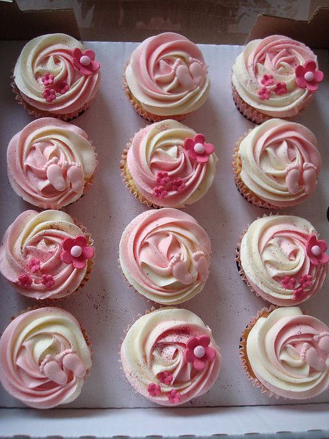 twelve cupcakes with pink frosting in a box