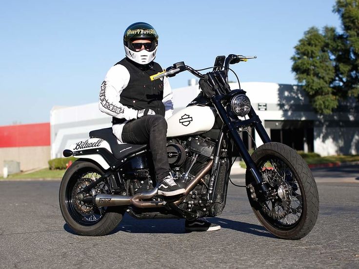 a man riding on the back of a motorcycle down a street