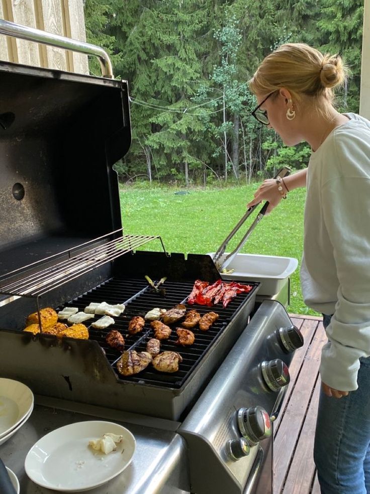 a woman grilling food on an outdoor grill