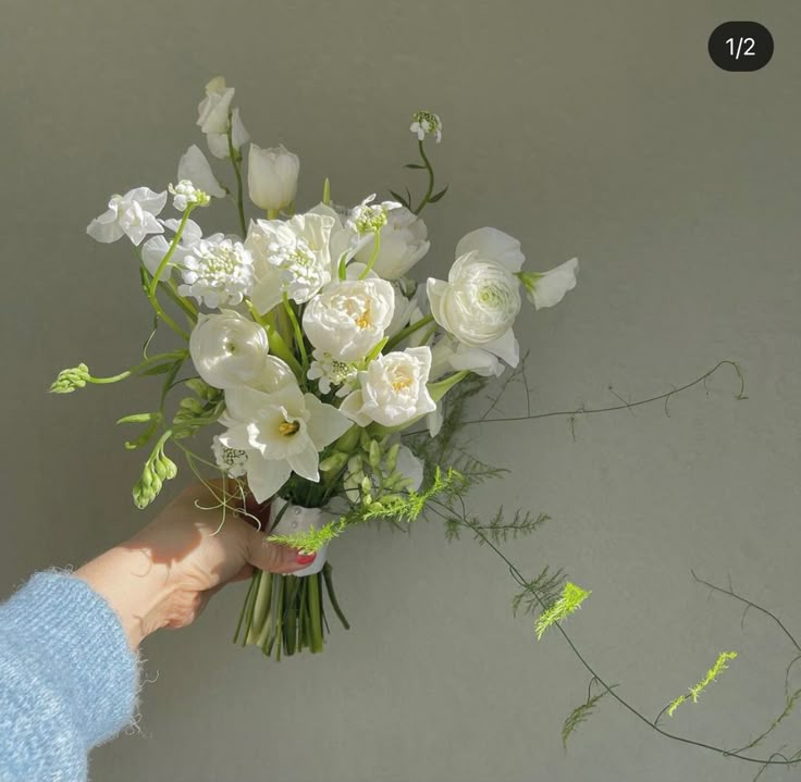 a person holding a bouquet of white flowers