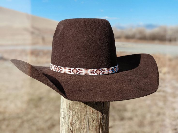 "Beaded hatband that was handmade in Montana using high quality glass seed beads. Contains dark brown, copper, gold, light pink, and white beads. They combine to make a beautiful and delicate rose gold effect. It is 1/2\" wide and 22.5\" long. (Should fit most cowboy hats sizes 7 and larger.) Finished with a leather and suede tie." Beaded Brown Hat Band For Festival, Beaded Brown Hat Bands For Festival, Festival Brown Beaded Hat Bands, Southwestern Brown Hat Band, Southwestern Style Brown Hat Band, Traditional Brown Beaded Hat Bands, Handmade Brown Hat Band As Gift, Western Brown Beaded Hat, Handmade Brown Hat Band For Gift